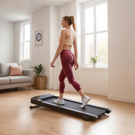 A woman walking on a treadmill in a bright, spacious living room with large windows.