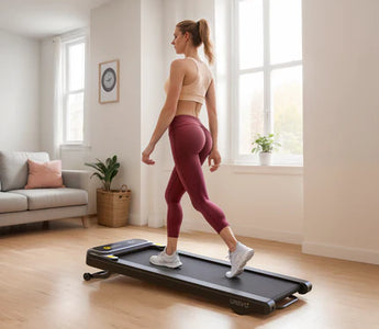 A woman walking on a treadmill in a bright, spacious living room with large windows.