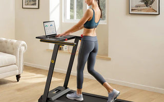 Woman walking on a treadmill while using a laptop in a home setting.