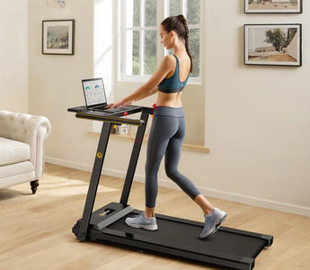 Woman walking on a treadmill while using a laptop in a home setting.